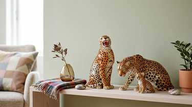 Leopard figurer opstillet på en lys flade ved en enkel væg