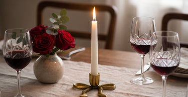 Nanda sløjfe lysestage i aluminium, guld fra Bloomingville, stillet op i et stemningsbillede til artiklen Romantisk middag for 2 hjemme: skab stemningen